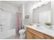 Bathroom features a shower and tub combo, white cabinets, and light fixtures at 6451 Crest Brook Way, Buford, GA 30518