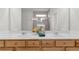 Bathroom featuring double sinks, light wood cabinets, and modern faucets at 6451 Crest Brook Way, Buford, GA 30518