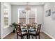 The dining room features a glass table and seating for four under a modern pendant light fixture at 6451 Crest Brook Way, Buford, GA 30518