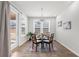 Bright dining room with a glass table, four chairs, and sliding door that leads to a backyard at 6451 Crest Brook Way, Buford, GA 30518