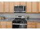 Modern kitchen features stainless steel appliances, granite countertops, and light wood cabinetry at 6451 Crest Brook Way, Buford, GA 30518