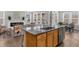 Open concept kitchen island with stainless steel dishwasher overlooking the living room and fireplace at 6451 Crest Brook Way, Buford, GA 30518