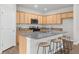 Bright kitchen featuring light wood cabinetry, granite countertops, and a convenient island with bar seating at 6451 Crest Brook Way, Buford, GA 30518