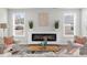 Inviting living room with a cozy fireplace, neutral furniture, and natural light from two windows at 6451 Crest Brook Way, Buford, GA 30518