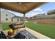 Relaxing covered patio features ceiling fan, modern seating and green backyard with scenic view at 6451 Crest Brook Way, Buford, GA 30518