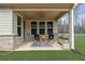 Inviting covered patio area with rocking chairs, brick accents and outdoor rug for relaxing at 6451 Crest Brook Way, Buford, GA 30518