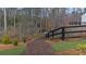 Scenic mulched walking path with a black fence, lush greenery and trees in a quiet neighborhood at 6451 Crest Brook Way, Buford, GA 30518