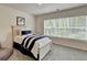 Bright bedroom with a large window, carpet, and a neatly made bed with blue and white striped accents at 5473 Blossomwood Sw Trl, Mableton, GA 30126