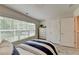 Bedroom featuring a bright window, closet doors, carpet, and a well-made bed with striped accents at 5473 Blossomwood Sw Trl, Mableton, GA 30126
