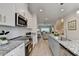 Open kitchen with modern appliances, granite countertops, and adjacent living area at 5473 Blossomwood Sw Trl, Mableton, GA 30126
