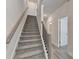 Carpeted staircase with modern railings leads to the upper levels of the home at 5473 Blossomwood Sw Trl, Mableton, GA 30126