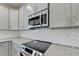 Close-up of stainless steel appliances, granite countertops, and white backsplash at 5477 Blossomwood Sw Trl, Mableton, GA 30126