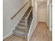 A staircase with carpeted treads, white risers, and a stained wood handrail at 5477 Blossomwood Sw Trl, Mableton, GA 30126