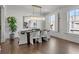 Bright dining room with hardwood floors, modern chandelier, white walls, and a view from adjacent windows at 620 Camp Ave, Roswell, GA 30075