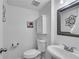 Half bath featuring a white sink, toilet, storage cabinet and decorative mirror at 5 Spring Green Pl, Atlanta, GA 30318