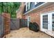 Private patio area with brick facade, seating area and grill for outdoor enjoyment at 5 Spring Green Pl, Atlanta, GA 30318