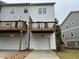 Back exterior view showing the wood decks and individual garages of the townhome at 5463 Blossomwood Sw Trl, Mableton, GA 30126
