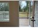 A view of the wood backyard deck and wooded view from the interior through a white door at 5463 Blossomwood Sw Trl, Mableton, GA 30126