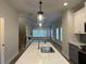 Bright kitchen island with a sink and pendant lighting that connects to the living area at 5463 Blossomwood Sw Trl, Mableton, GA 30126