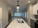 Kitchen island with quartz countertop and open view into the living room at 5463 Blossomwood Sw Trl, Mableton, GA 30126