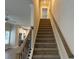 Carpeted staircase with stained wood banister and black iron balusters leading up to the next floor at 5463 Blossomwood Sw Trl, Mableton, GA 30126
