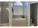 Bathroom featuring tiled surround, a shower, and a large window at 1507 Smithfield Dr, Mcdonough, GA 30252