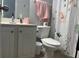 Cozy bathroom features a vanity with storage, toilet and shower with a floral curtain at 1507 Smithfield Dr, Mcdonough, GA 30252
