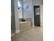 Bathroom featuring tiled surround, a shower, and a large window at 1507 Smithfield Dr, Mcdonough, GA 30252