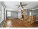 Open living room featuring a stone fireplace, ceiling fan, and hardwood floors at 1472 Norman Berry Dr, Atlanta, GA 30344