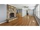 Open living room with hardwood floors, stone fireplace, and modern ceiling fans at 1472 Norman Berry Dr, Atlanta, GA 30344