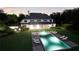 Nighttime aerial view of a backyard oasis with a pool, hot tub, and well-lit outdoor lounge area at 4428 Blackland Dr, Marietta, GA 30067