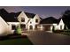 Elegant home exterior illuminated at twilight, featuring a stone arch entry, lush landscaping, and attached garage at 4428 Blackland Dr, Marietta, GA 30067