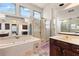 Bright bathroom features a soaking tub, a separate shower, vanity and large mirror at 211 Congress Pkwy, Lawrenceville, GA 30044
