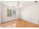 This sunny bedroom has a ceiling fan, large window, and hardwood flooring at 211 Congress Pkwy, Lawrenceville, GA 30044