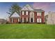 Charming brick home with a well-manicured lawn, black shutters, and beautiful architectural details at 211 Congress Pkwy, Lawrenceville, GA 30044