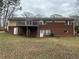 Back exterior view featuring brickwork, a deck, and a spacious yard at 5862 Kitchens Se Rd, Mableton, GA 30126
