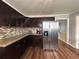 Spacious kitchen featuring stainless steel appliances, granite countertops, and dark wood cabinets at 5862 Kitchens Se Rd, Mableton, GA 30126