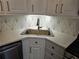 Close up of the updated kitchen featuring stylish backsplash, stainless steel sink, and sleek faucet at 742 Olde Towne Ln, Marietta, GA 30068