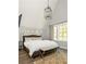 Serene bedroom with natural light, a plush bed, stylish decor, and hardwood floors at 10594 Serenbe Ln, Chattahoochee Hills, GA 30268