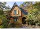 Charming shingle-style home with lush landscaping and arched front door creates a warm, inviting curb appeal at 10594 Serenbe Ln, Chattahoochee Hills, GA 30268