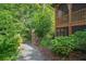Beautiful stone walkway and lush greenery leading to a charming house with a screened porch at 10594 Serenbe Ln, Chattahoochee Hills, GA 30268