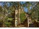 Exterior shot of home surrounded by lush greenery, showcasing the architectural details at 10594 Serenbe Ln, Chattahoochee Hills, GA 30268