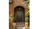 A beautifully crafted arched front door, flanked by manicured topiaries, welcomes you to this inviting home at 10594 Serenbe Ln, Chattahoochee Hills, GA 30268