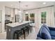 Modern kitchen featuring stainless steel appliances and a gray island with bar stools at 10594 Serenbe Ln, Chattahoochee Hills, GA 30268