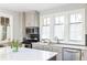 Modern kitchen features stainless steel appliances, light gray cabinets, and a center island with seating at 10594 Serenbe Ln, Chattahoochee Hills, GA 30268