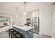 Modern kitchen featuring stainless steel appliances, a gray island with bar stools, and white cabinets at 10594 Serenbe Ln, Chattahoochee Hills, GA 30268