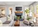 Bright living room featuring a fireplace, large windows offering a view of the yard, and comfortable seating arrangement at 10594 Serenbe Ln, Chattahoochee Hills, GA 30268