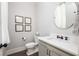 Stylish powder room with a round mirror, elegant fixtures, and tastefully framed artwork at 10594 Serenbe Ln, Chattahoochee Hills, GA 30268