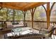 Relaxing screened porch with a swing, ceiling fan, and comfortable seating, perfect for enjoying the outdoors at 10594 Serenbe Ln, Chattahoochee Hills, GA 30268