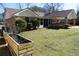 Exterior back elevation shows patio, sunroom, and spacious backyard with garden at 575 Midland Park Dr, Stone Mountain, GA 30087